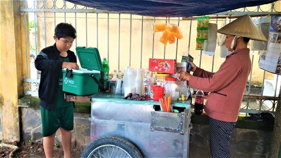 Hàng ngày em Hiếu vẫn phụ mẹ đẩy xe bán nước giải khát bên cạnh trường Tiểu học Tân Hương B.